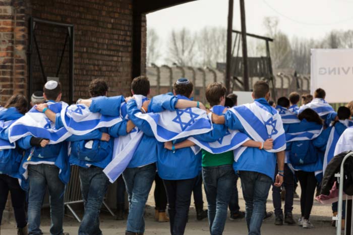 בחוקים ישראלים הולכים במחנה ריכוז עם דגל ישראל