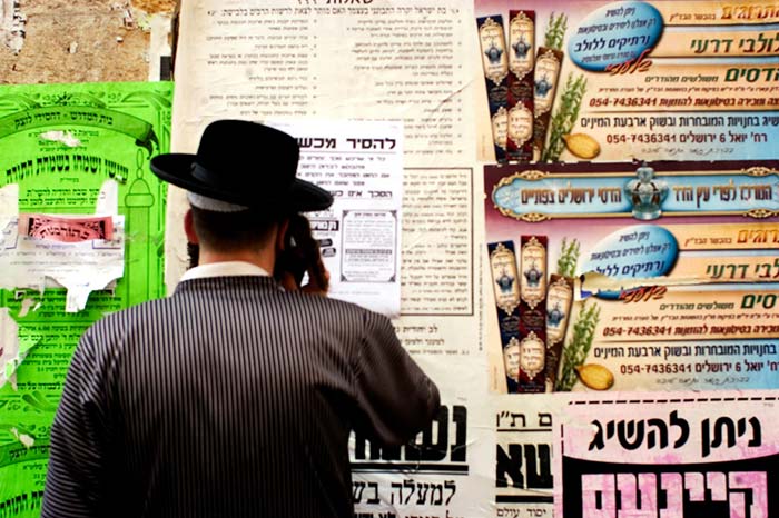 איש קורא לוח מודעות במאה שערים