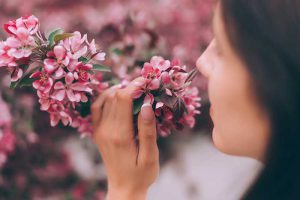 אישה מריחה פרחים