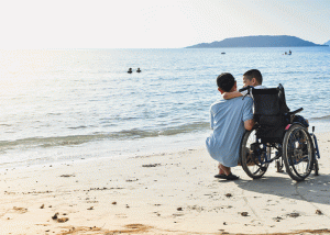 ילד עם כסא גלגלים מול הים